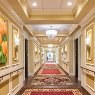 A beautifully decorated hotel hallway featuring elegant lighting and vibrant artwork.
