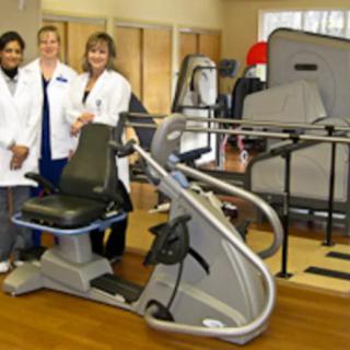 Healthcare professionals in a rehabilitation center with exercise equipment.