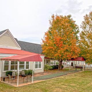 A house with a patio and trees displaying autumn colors.