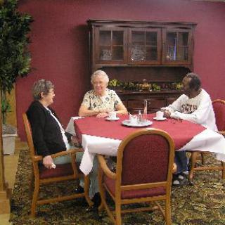 Three people sitting around a table having a conversation.
