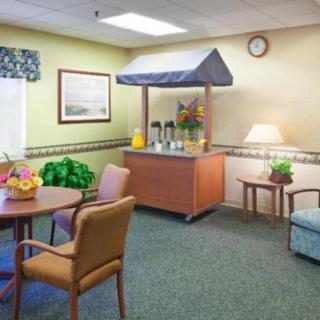 A cozy room featuring a beverage station, table with chairs, and decorative elements.