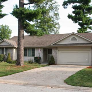 A charming single-story house with a well-maintained front yard and driveway.