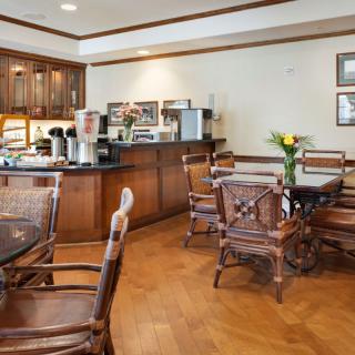 A cozy cafe seating area with wooden furniture and a coffee station.