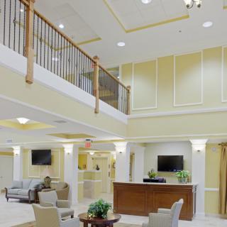 A modern and spacious lobby with elegant furniture and a reception desk.