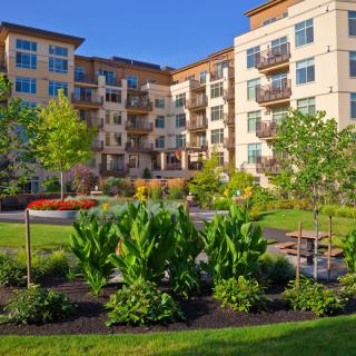 A modern apartment building with well-maintained gardens and green spaces.
