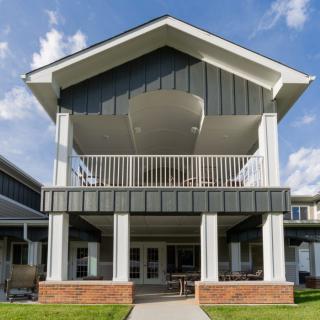 Front view of a residential building with a balcony and porch.