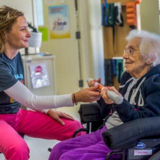 A caregiver interacting with an elderly person in a nursing home.