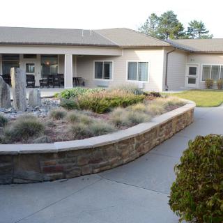 A view of a modern building with a landscaped courtyard and garden.
