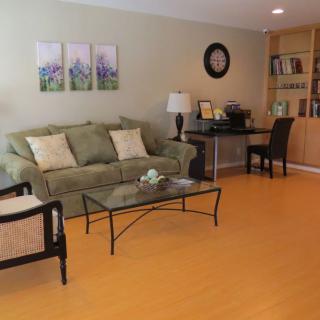 A cozy living room with a comfortable sofa, glass coffee table, and bookshelf.