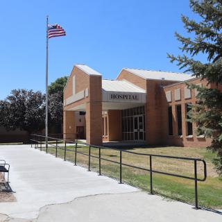 A clear view of a school building with an American flag flying in front.