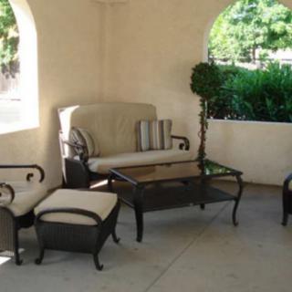 A cozy outdoor seating area with cushioned furniture set under a covered patio.