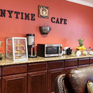 A cozy cafe interior with a counter featuring a microwave, coffee machine, and snack display.
