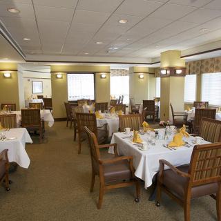 Spacious dining room with elegantly set tables and comfortable seating.