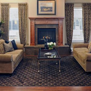 A cozy living room featuring two sofas, a central coffee table, and a fireplace.