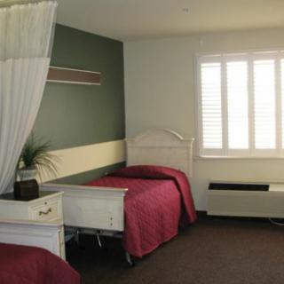 A cozy bedroom with two single beds, a window, and simple decor.