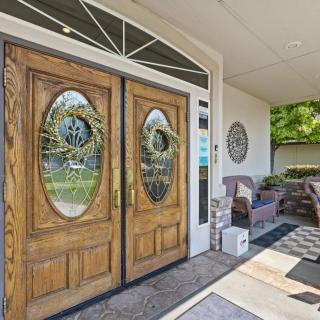 A welcoming entrance with wooden double doors adorned with wreaths, leading to a cozy porch area featuring outdoor seating.