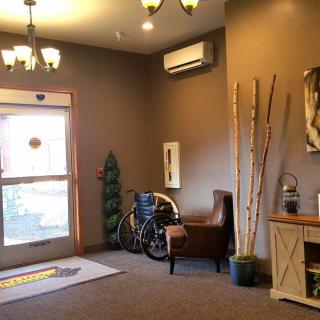 A cozy lobby area with a bicycle near the entrance, surrounded by decorative plants and furnishings.