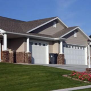 Suburban houses with attached garages and well-maintained lawns.