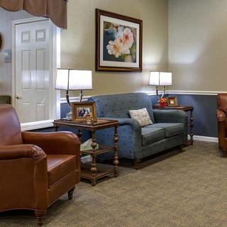 A cozy living room with a sofa, armchairs, and warm lighting.