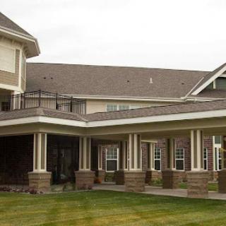 A modern residential building with a landscaped lawn.