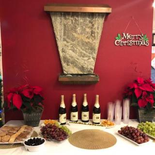 A festive Christmas setup with wine, grapes, and poinsettias.