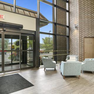A modern lobby with large glass doors, comfortable seating, and expansive windows.