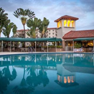 A serene outdoor swimming pool at a hotel resort surrounded by palm trees.