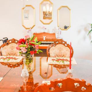 A beautifully arranged dining room with ornate chairs, a floral centerpiece, and mirrors reflecting the warm decor.