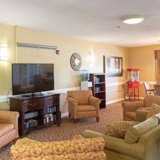 A cozy living room with comfortable seating, a TV, and a popcorn machine.