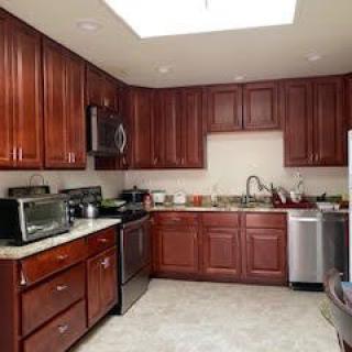 A modern kitchen with wooden cabinets and various appliances.