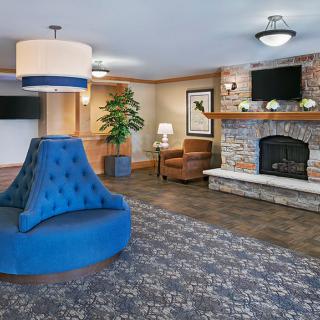 A modern hotel lobby featuring a cozy fireplace, elegant seating, and stylish decor.