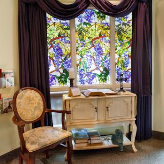 A beautifully designed corner featuring a stained glass window and elegant furniture.