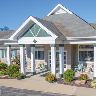 A modern building entrance with columns and landscaped surroundings.