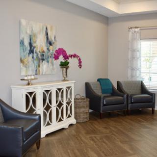 A cozy and modern living room featuring elegant seating, a stylish console, and vibrant artwork.