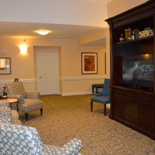 A cozy living room featuring comfortable chairs, a large television, and elegant interior decor.
