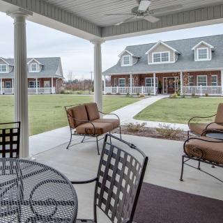 A cozy outdoor patio with comfortable seating and a view of charming houses.
