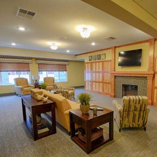 A cozy living room with comfortable seating, a fireplace, and a wall-mounted television.
