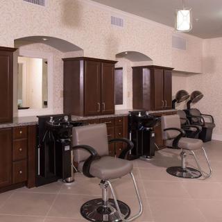 An empty hair salon featuring styling chairs and mirrors.