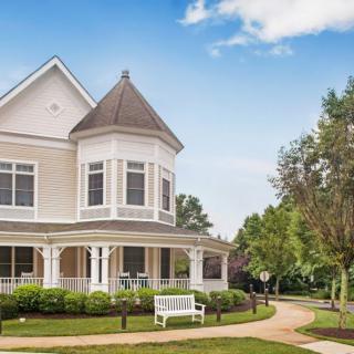 A charming Victorian-style house with a wraparound porch and landscaped garden.