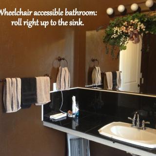 A wheelchair-accessible bathroom with a roll-up sink.
