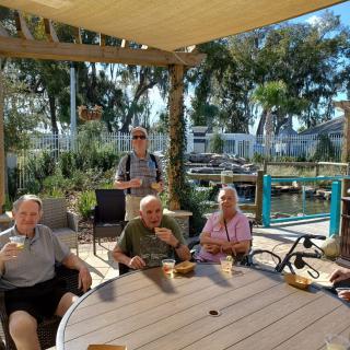 A group of people enjoying a relaxed gathering on a sunny outdoor patio.