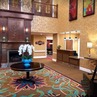 A well-furnished hotel lobby with a fireplace, reception desk, and colorful decor.