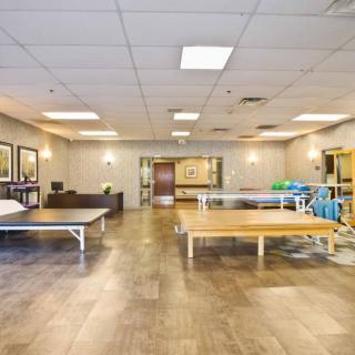 A spacious rehabilitation therapy room equipped with exercise tables and equipment.