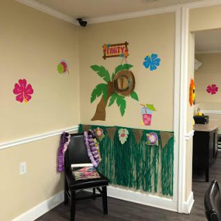 A bright and cheerful tropical-themed decor featuring flowers, a palm tree, and playful elements.