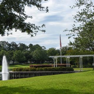 A peaceful park scene with a fountain and lush greenery.