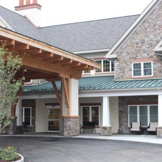 A residential building with a stone facade and a covered entrance.