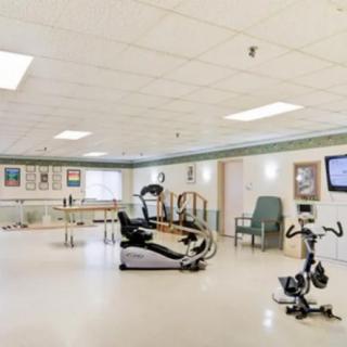 A spacious indoor gym area featuring various exercise equipment, including a treadmill and stationary bike.
