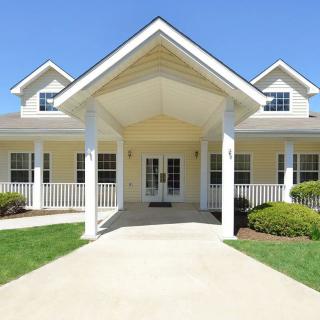 A beautiful suburban house with a large porch and well-maintained garden.