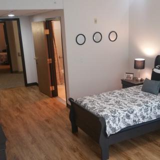 A minimalist bedroom with wood flooring and a single bed.