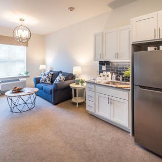 A modern apartment featuring an open living room and kitchen area with stylish furnishings.